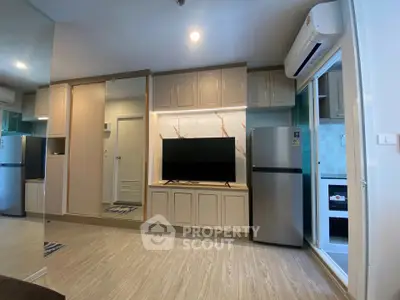 Modern living room with sleek design, featuring built-in TV unit and open kitchen layout.
