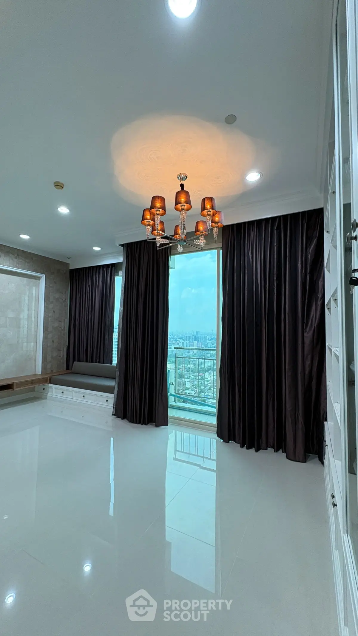 Luxurious living room with elegant chandelier and panoramic city view.