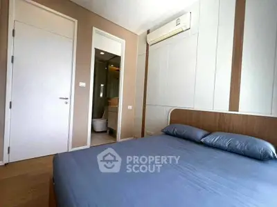 Modern bedroom with ensuite bathroom and air conditioning in stylish apartment.