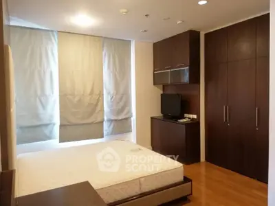 Spacious bedroom with modern furnishings and ample natural light.