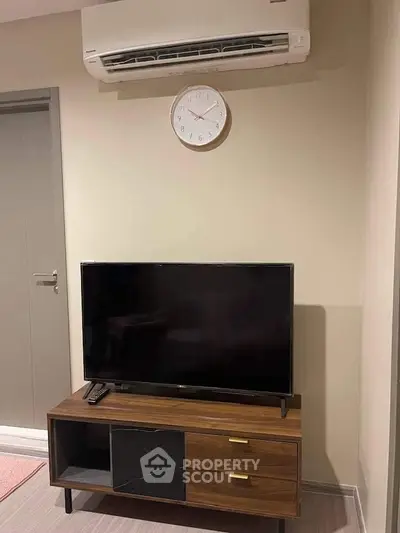 Modern living room with sleek TV stand and wall-mounted air conditioner, perfect for cozy entertainment.