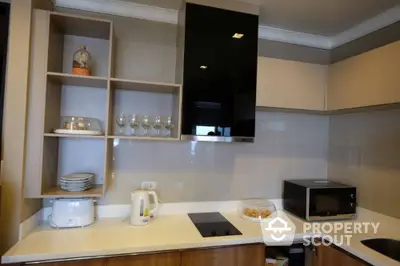 Modern kitchen with sleek cabinetry, built-in stove, and microwave, perfect for culinary enthusiasts.