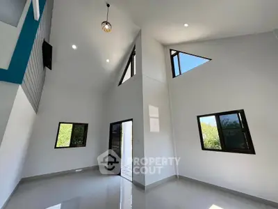 Modern high-ceiling interior with unique architectural design and large windows.