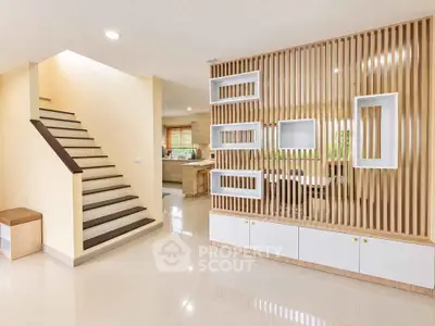 Modern open-plan living area with stylish staircase and wooden partition