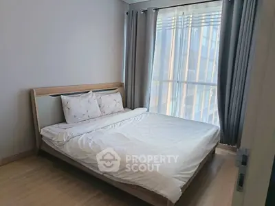 Modern bedroom with large window and stylish bed in a contemporary apartment.