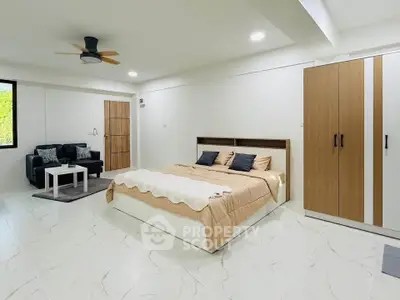 Spacious modern bedroom with elegant decor and ample natural light