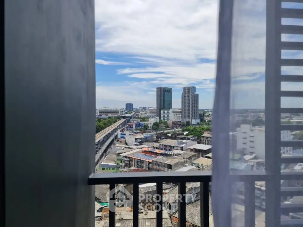 Stunning urban view from a high-rise balcony overlooking city skyline and railway.