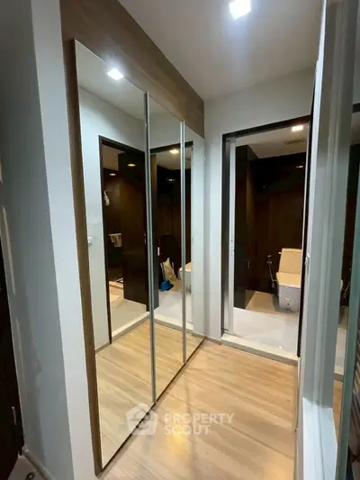 Modern interior with mirrored closet doors and sleek bathroom entrance