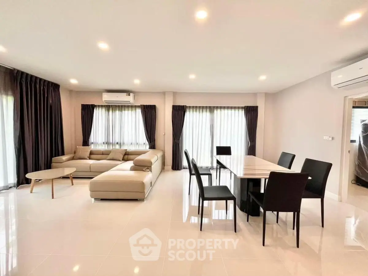 Spacious modern living room with elegant dining area and large windows for natural light.