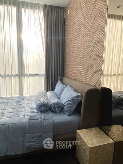 Luxurious bedroom with elegant decor and large windows offering natural light.