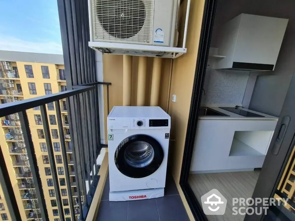 Compact balcony with washing machine and city view in modern apartment