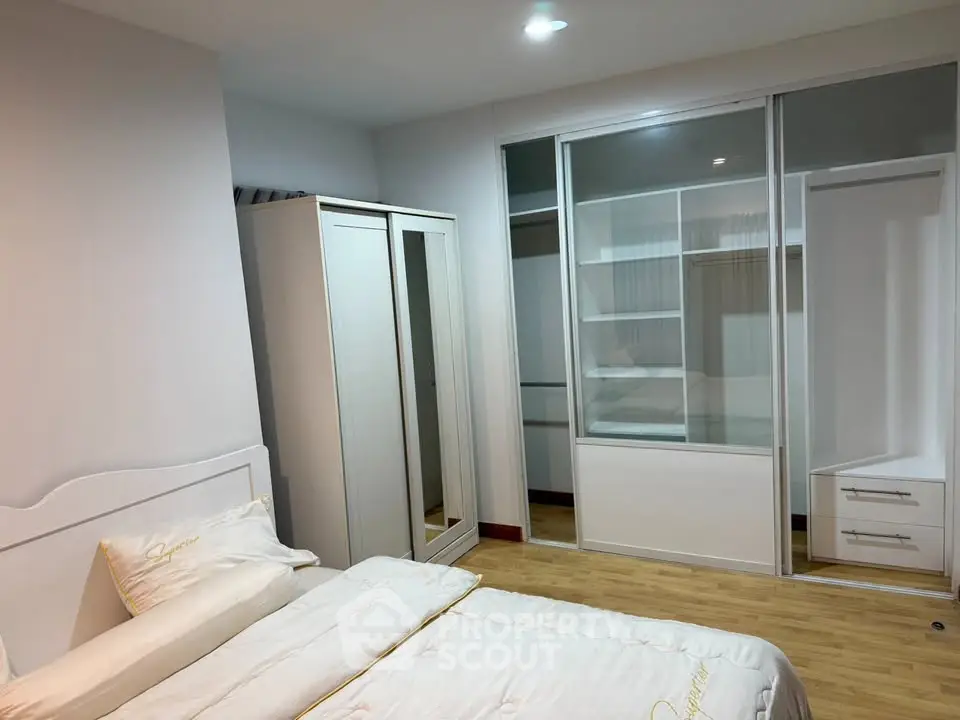 Spacious bedroom with modern wardrobe and cozy bed in a stylish apartment.