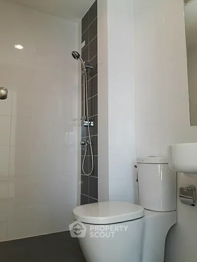 Modern bathroom with sleek shower and toilet in contemporary apartment.