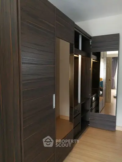 Spacious modern wardrobe with mirrored doors in a stylish bedroom setting.