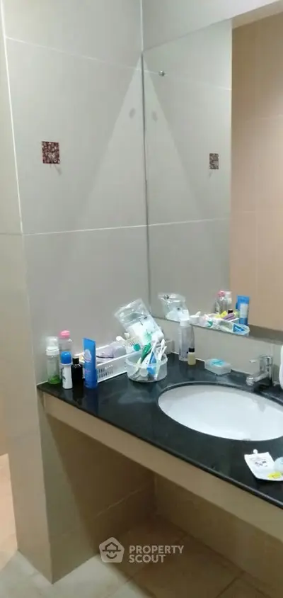 Modern bathroom with sleek countertop and mirror, showcasing contemporary design and functionality.