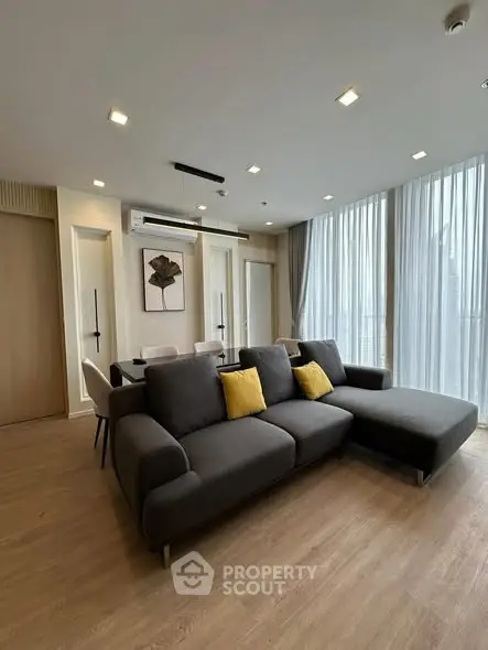 Modern living room with sleek furniture and large windows in a stylish apartment.