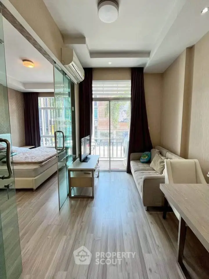 Modern studio apartment with glass partition, cozy living area, and natural light.