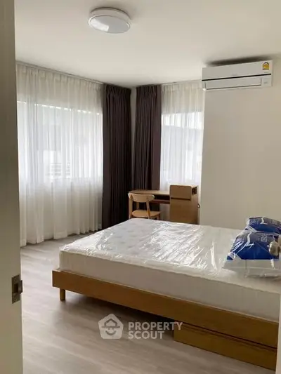 Spacious bedroom with modern furniture and natural light