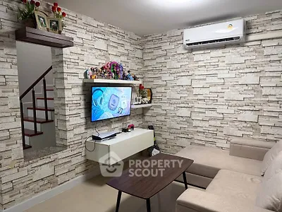 Stylish living room with modern decor and wall-mounted TV, perfect for relaxation and entertainment.