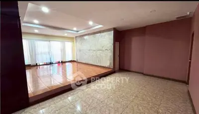 Spacious living room with elevated platform and large windows for natural light.