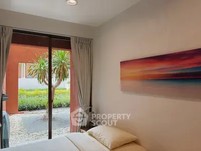 Cozy bedroom with garden view and modern decor in a serene residential setting.