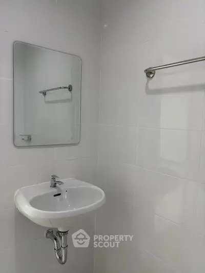 Compact bathroom with white sink and mirror, ideal for minimalist design.