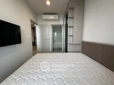 Modern bedroom with air conditioning and wall-mounted TV in a stylish apartment.