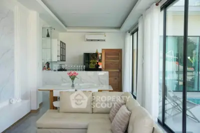 Modern living room with open kitchen and pool view, featuring elegant marble accents and cozy seating area.