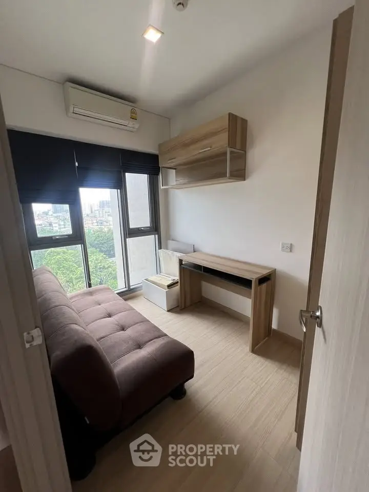 Modern study room with large window and stylish furniture in a high-rise apartment.