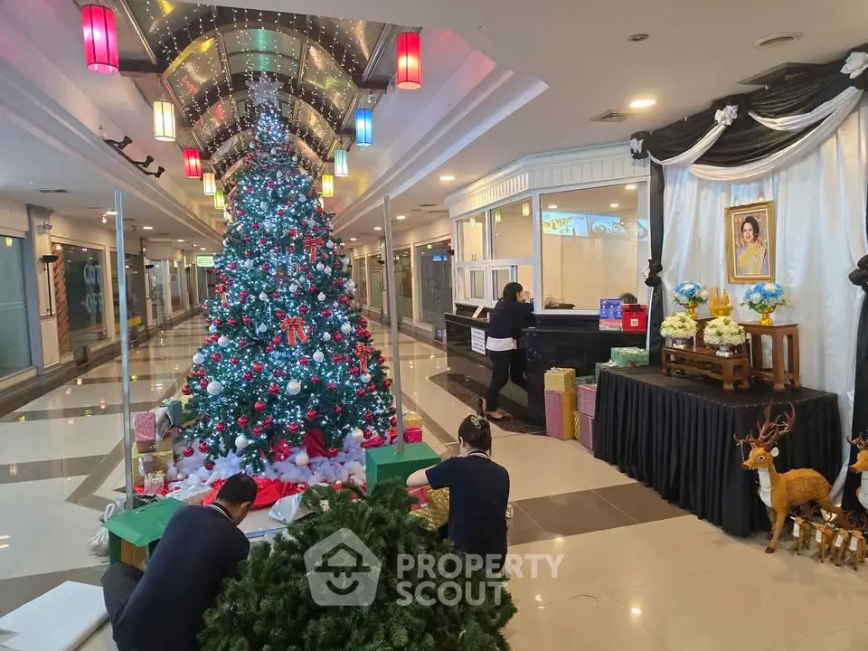 Festive building entrance with Christmas tree and decorations, creating a welcoming holiday atmosphere.