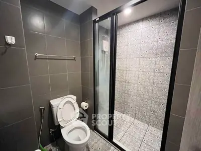 Modern bathroom with sleek shower and tiled walls in contemporary home.