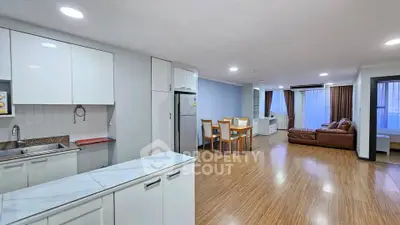 Spacious open-plan kitchen and living area with modern furnishings and wooden flooring.