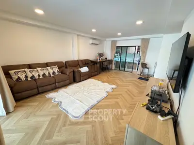 Spacious living room with modern decor and large brown sofa, perfect for relaxation and entertainment.
