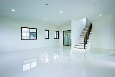 Spacious modern living room with sleek staircase and large windows