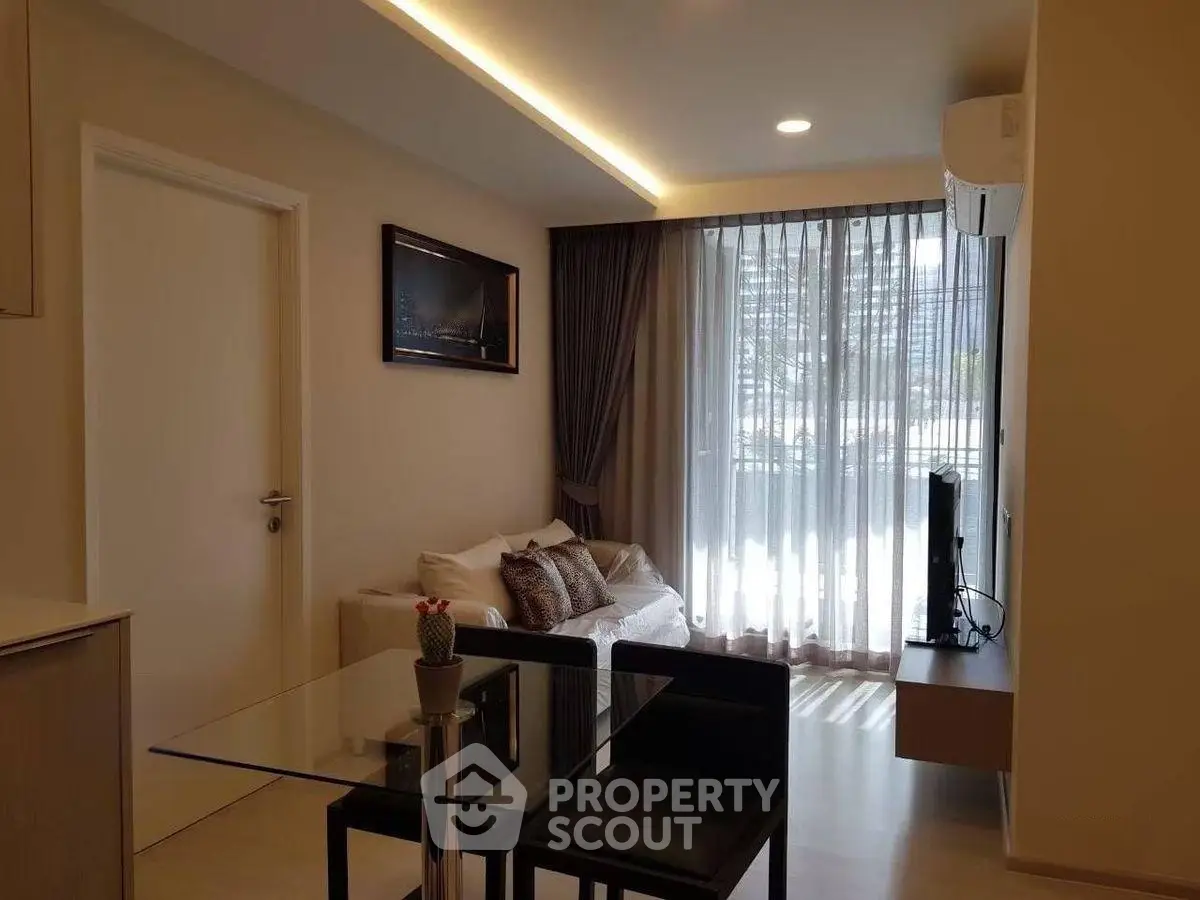 Modern living room with sleek furniture and large window for natural light.