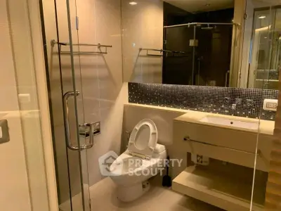 Modern bathroom with glass shower and sleek fixtures in a contemporary apartment.