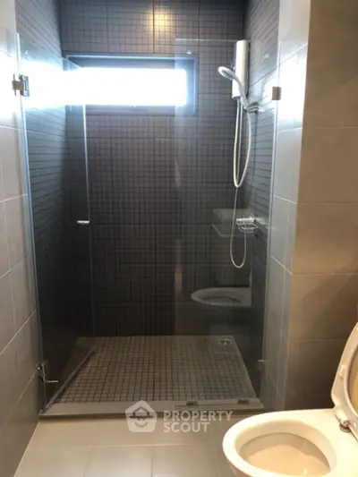 Modern bathroom with glass shower enclosure and sleek tile design.