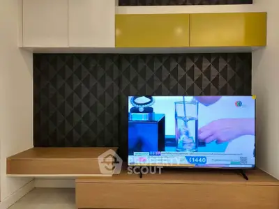 Modern living room with stylish TV unit and geometric wall design