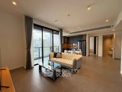 Spacious modern living room with city view, open kitchen, and elegant decor in high-rise apartment.
