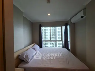 Modern bedroom with large window and air conditioning in urban apartment.
