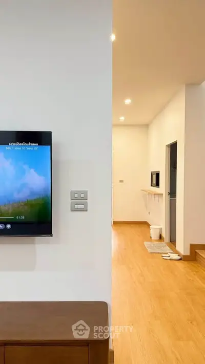 Modern interior with wooden flooring and wall-mounted TV in a cozy living space.