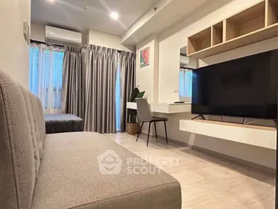 Modern living room with stylish decor and large TV, perfect for relaxation.