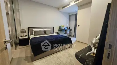 Modern bedroom with stylish decor and workspace, featuring a cozy bed and elegant furnishings.