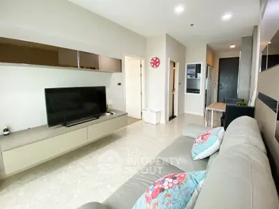 Modern living room with sleek design, featuring a comfortable sofa, wall-mounted TV, and stylish decor.