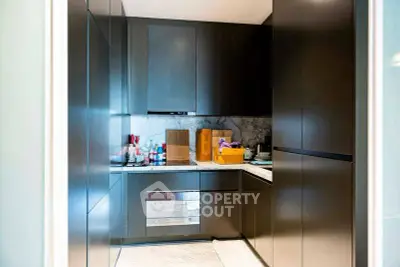 Modern kitchen with sleek cabinetry and marble backsplash in a luxury apartment.
