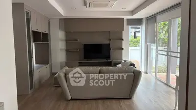 Modern living room with sleek design and large windows offering natural light.
