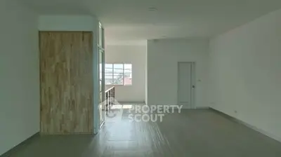 Spacious unfurnished living room with large window and wooden accents