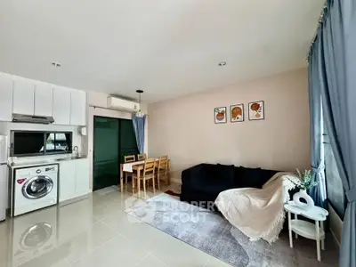 Modern living room with open kitchen, cozy sofa, and dining area in a bright apartment.