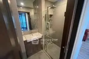 Modern bathroom with glass shower and sleek vanity in a contemporary home.