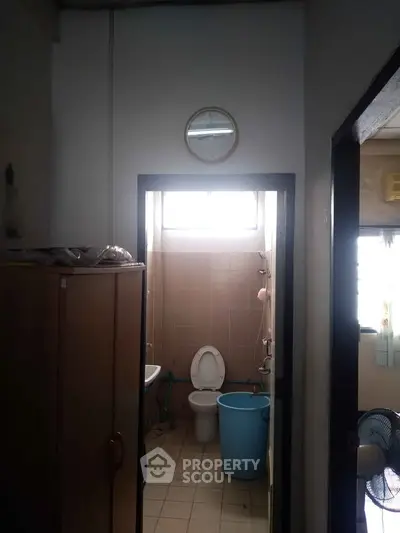 Compact bathroom with basic fixtures and natural light